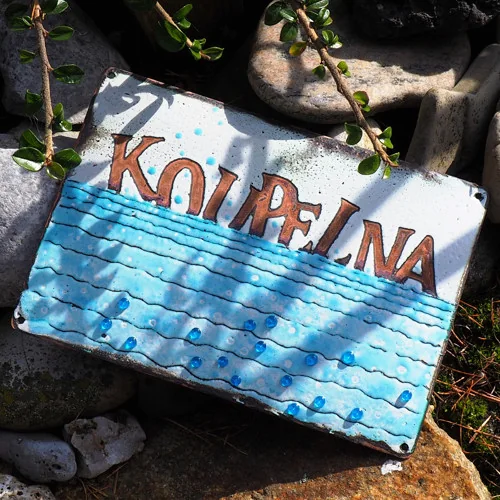 Emaille-Türschild „Koupelna“ mit blauem Wassermotiv.