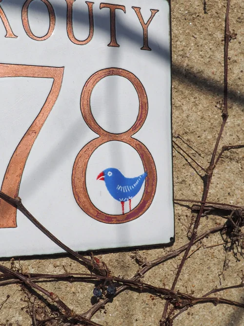 Hausschild „Kouty 78“ mit blauem Vogel — Feueremaille auf Kupfer